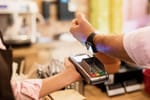 Mann zahlt mit Uhr und benutzt kein Bargeld mehr.