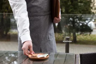 Ein Kellner nimmt eine Schüssel mit Bargeld