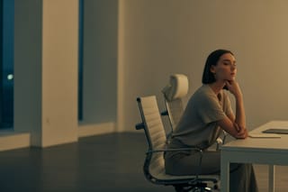 Eine Frau sitzt nachdenklich da